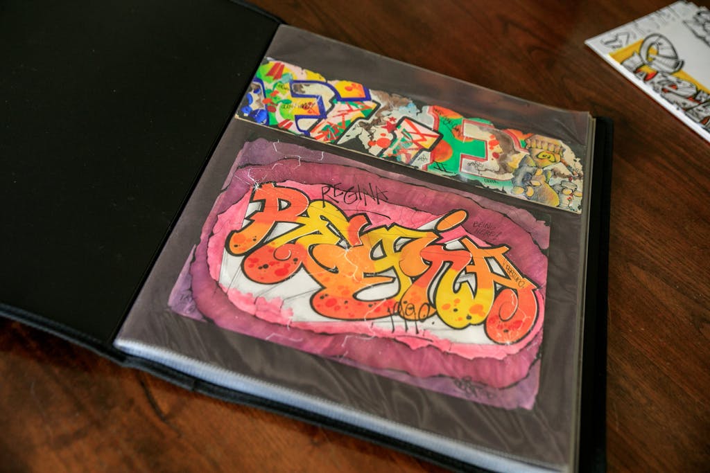 Vibrant graffiti art showcased in a sketchbook on a wooden table, perfect for art enthusiasts.